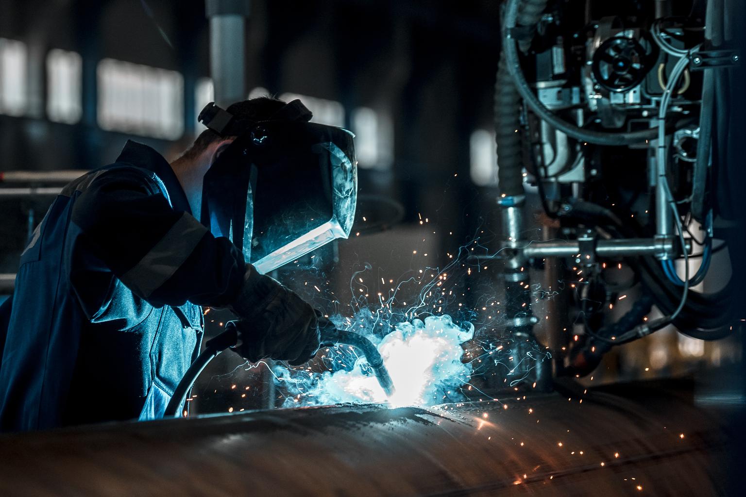 Man,Welds,At,The,Factory